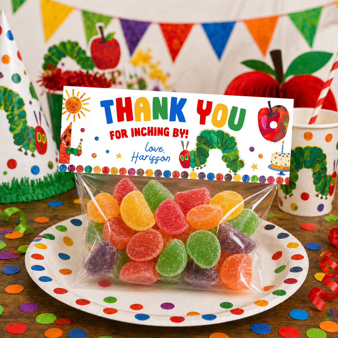Printable Hungry Caterpillar party favor bag topper attached to a clear candy bag filled with colorful jelly candies, featuring “Thank You For Inching By” text and caterpillar illustrations on a bright birthday party dessert table backdrop.