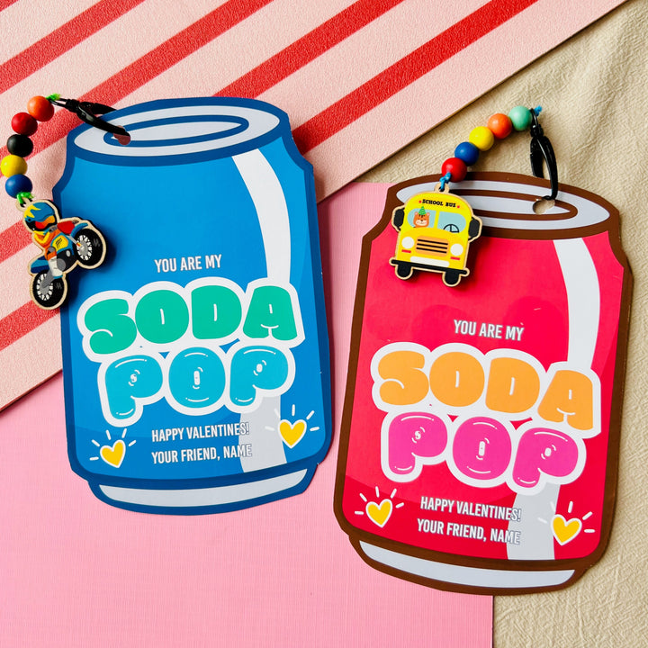 Two 'You Are My Soda Pop' keychains on a striped background
