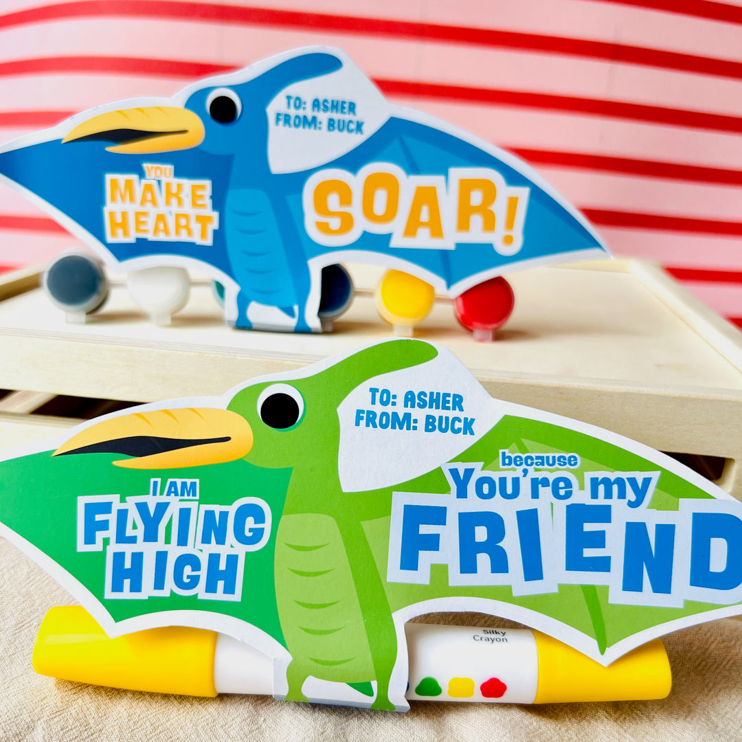 Close-up of printable pterodactyl card holding small gifts with "I Am Flying High" pun for boys' valentines day gifting